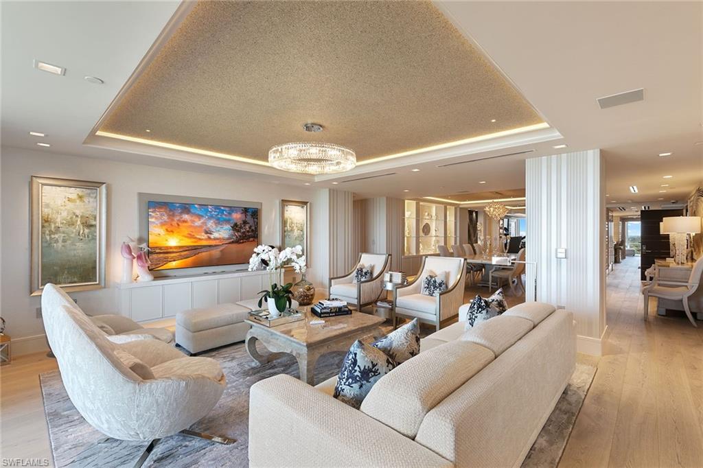 6897 Grenadier Boulevard, Unit 1202 Naples, FL 34108 - Photo 2 of 50 a living room with fireplace furniture and a chandelier