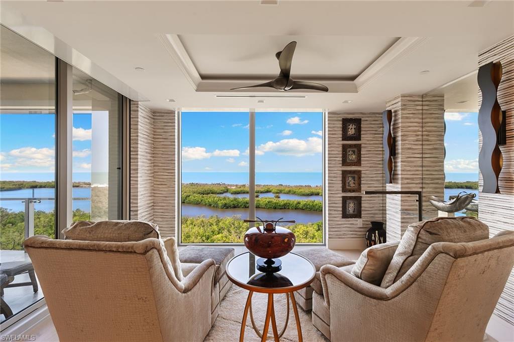 6897 Grenadier Boulevard, Unit 1202 Naples, FL 34108 - Photo 28 of 50 a living room with furniture and floor to ceiling windows