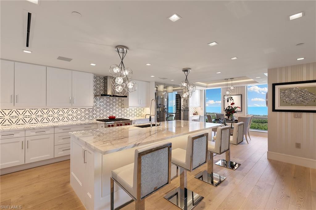 6897 Grenadier Boulevard, Unit 1202 Naples, FL 34108 - Photo 3 of 50 a kitchen with stainless steel appliances kitchen island granite countertop a sink and cabinets