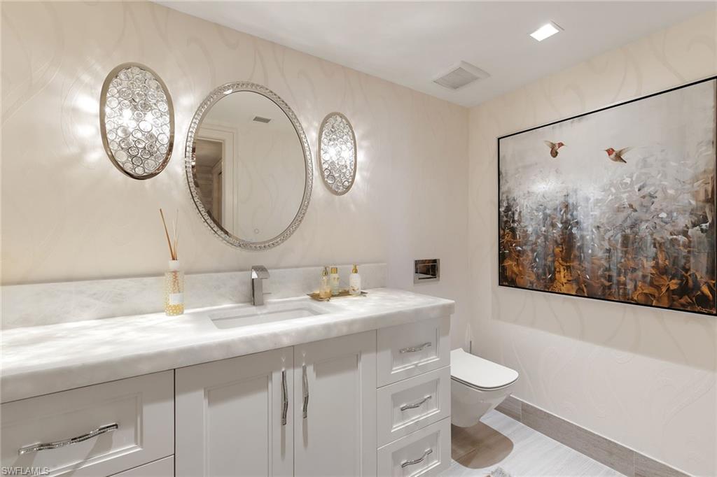 6897 Grenadier Boulevard, Unit 1202 Naples, FL 34108 - Photo 35 of 50 a bathroom with a toilet a sink and a mirror