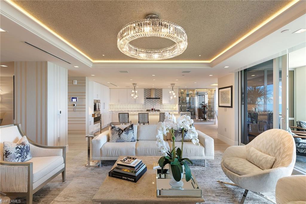 6897 Grenadier Boulevard, Unit 1202 Naples, FL 34108 - Photo 9 of 50 a living room with furniture and a chandelier