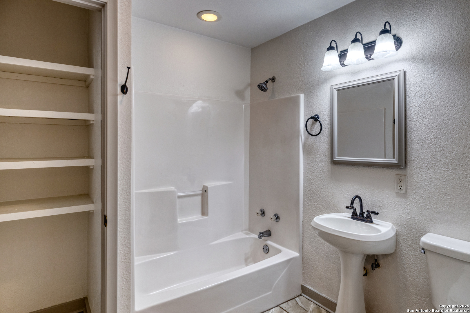 214 West Frio Street Uvalde, TX 78801 - Photo 16 of 35 a bathroom with a sink a toilet and a mirror