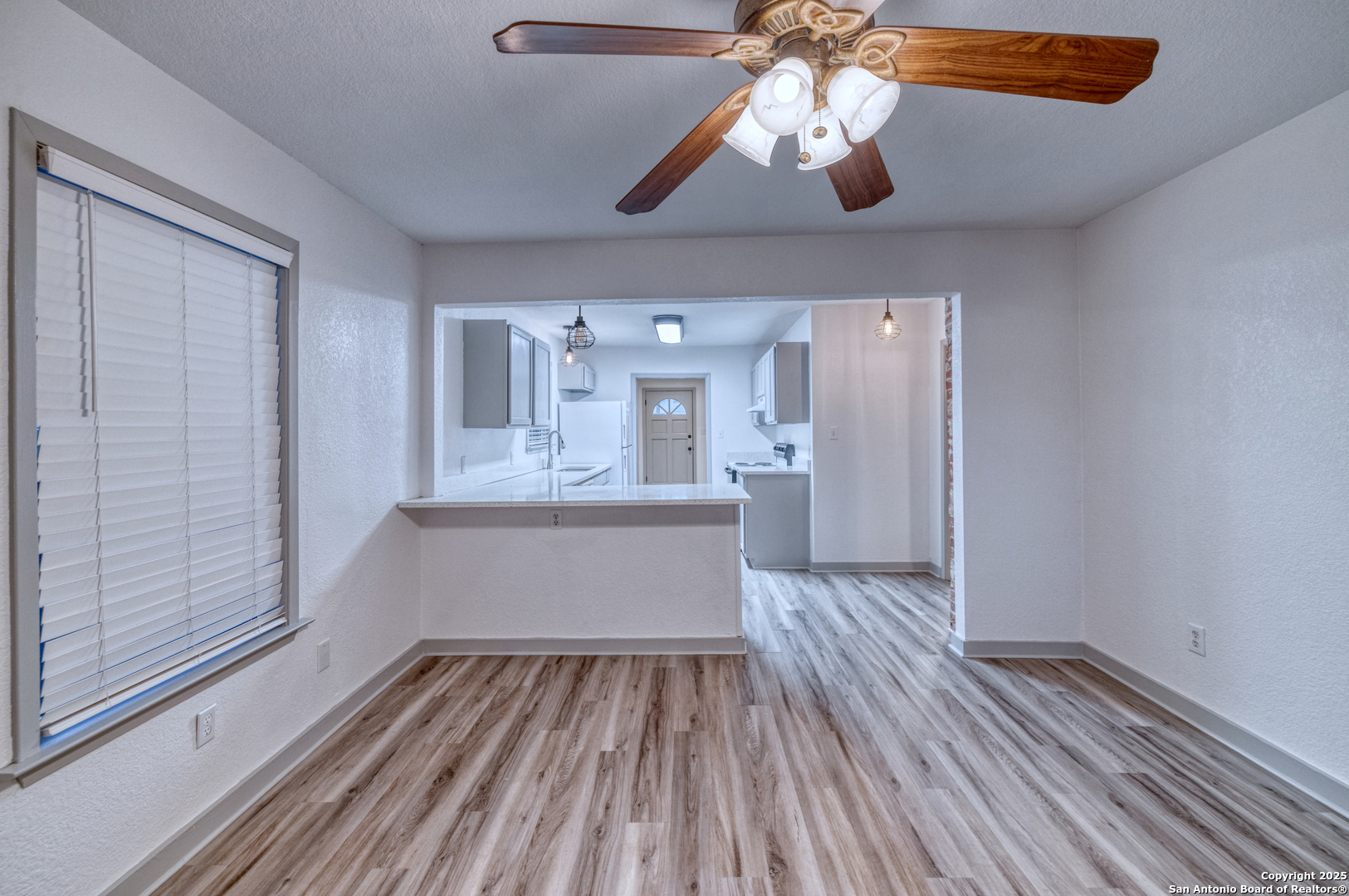 214 West Frio Street Uvalde, TX 78801 - Photo 6 of 35 a view of kitchen and empty room with wooden floor