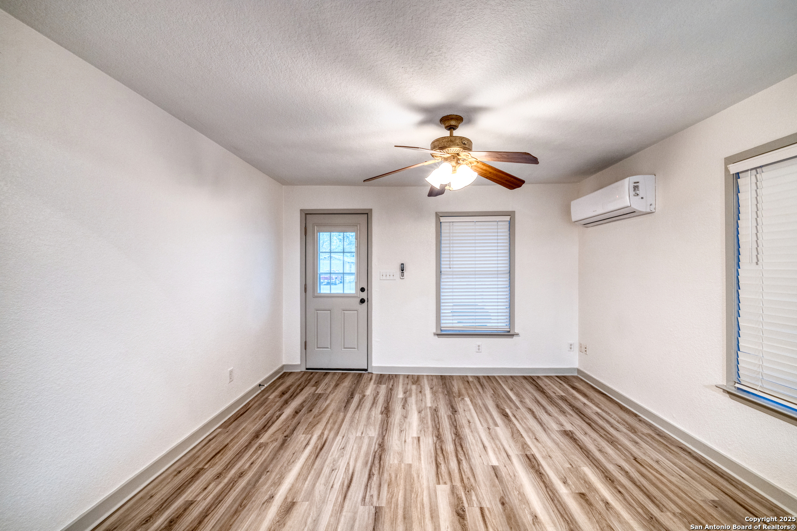 214 West Frio Street Uvalde, TX 78801 - Photo 7 of 35 a view of empty room with wooden floor and fan