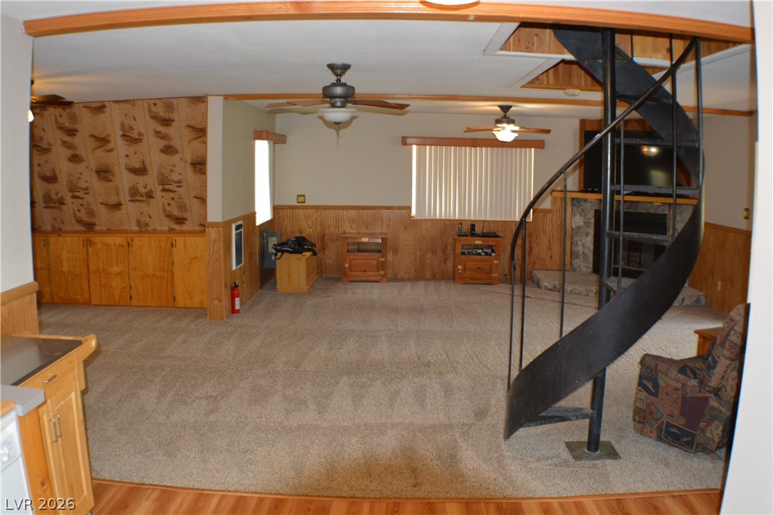 1321 Trout Canyon Road Las Vegas, NV 89124 - Photo 17 of 50 A spacious living area showcasing warm wood paneling, comfortable carpeting, and a unique spiral staircase leading to another level.