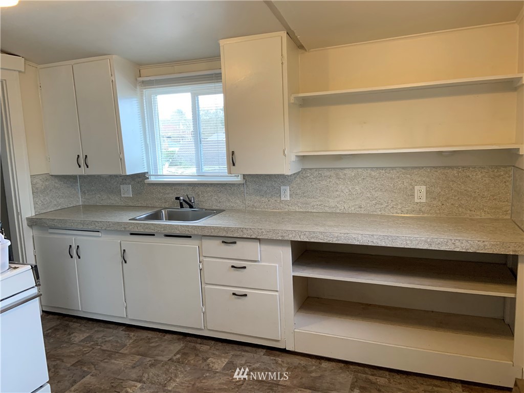 129 Wells Avenue North Renton, WA 98057 - Photo 22 of 29 a kitchen with granite countertop white cabinets and a sink