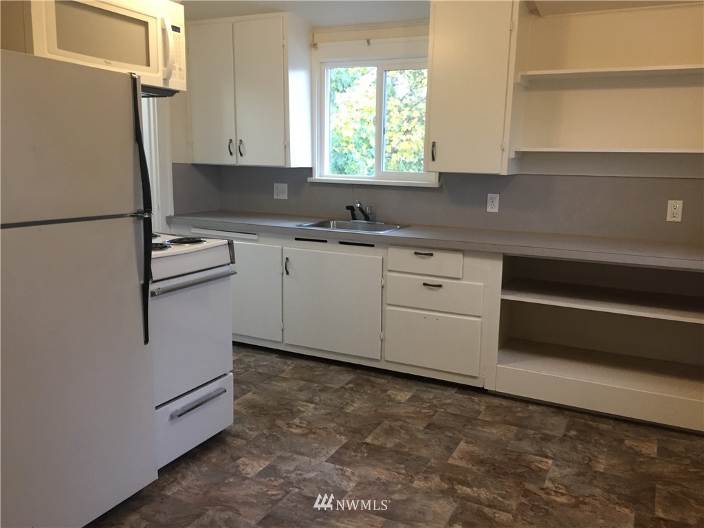 129 Wells Avenue North Renton, WA 98057 - Photo 23 of 29 a kitchen with granite countertop white cabinets and white appliances