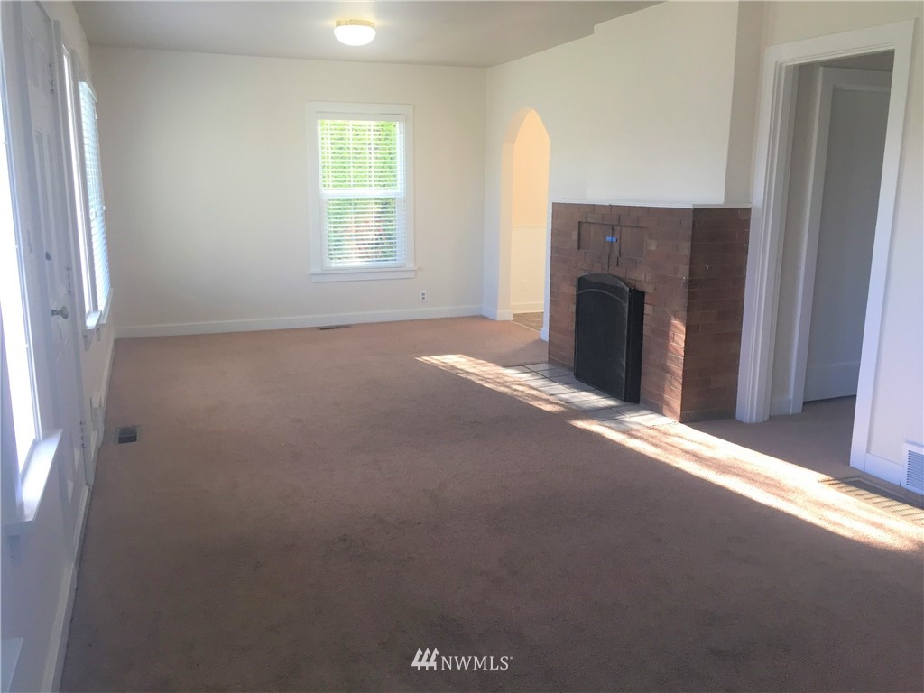 129 Wells Avenue North Renton, WA 98057 - Photo 7 of 29 a view of a livingroom with an empty space and a fireplace