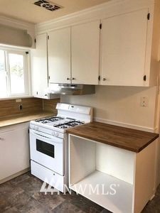 129 Wells Avenue North Renton, WA 98057 - Photo 10 of 29 a kitchen with stainless steel appliances granite countertop a stove a sink and white cabinets