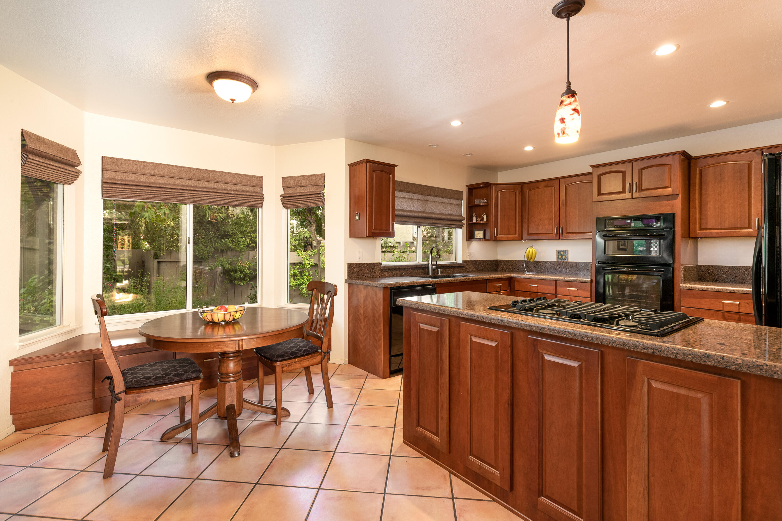 352 Nykobing Solvang, CA 93463 - Photo 6 of 27 a kitchen with stainless steel appliances granite countertop a stove a sink dishwasher a dining table and chairs with wooden floor