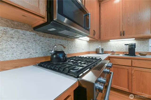 a kitchen with stainless steel appliances granite countertop a sink stove and cabinets