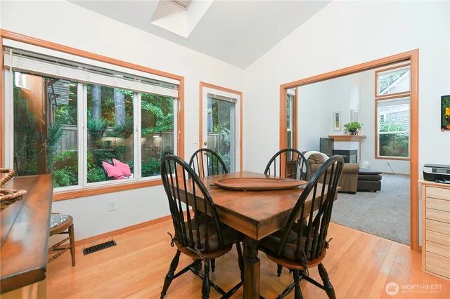 a dining room with furniture large windows and wooden floor