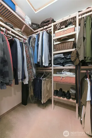 a view of walk in closet with clothes and shoes