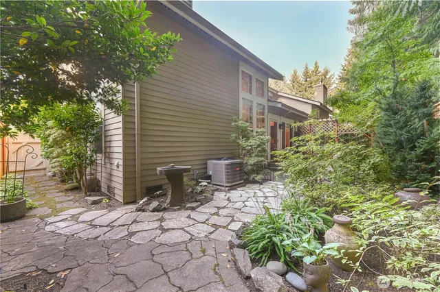 a backyard of a house with table and chairs and potted plants