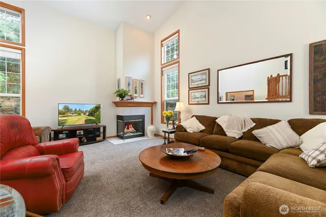 a living room with furniture a fireplace and a large window