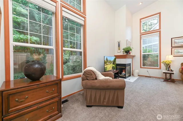 a living room with furniture a fireplace and a floor to ceiling window