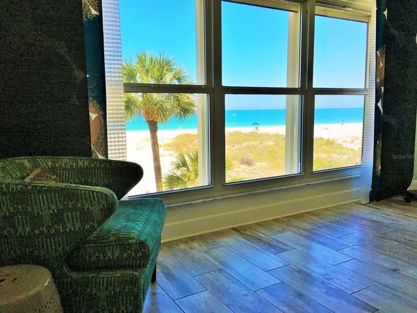 a living room with a floor to ceiling window and wooden floor