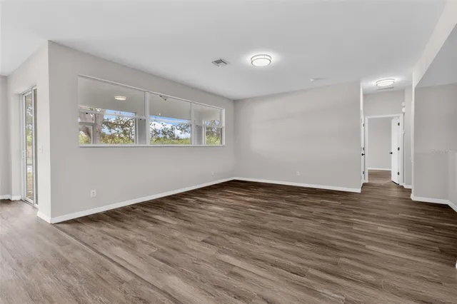 a kitchen with cabinets stainless steel appliances and wooden floor