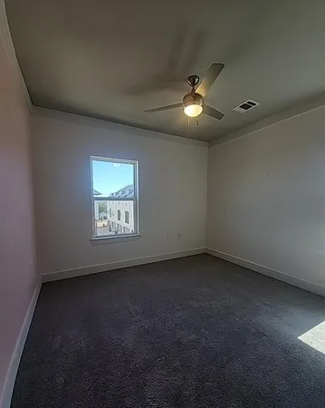a view of an empty room with a chandelier fan