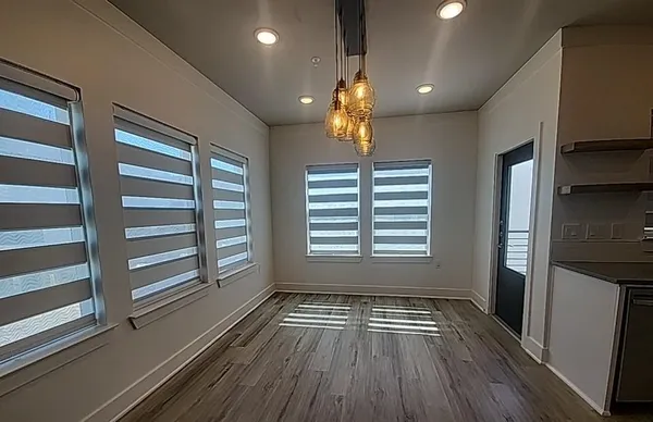 a kitchen with granite countertop a refrigerator sink and white cabinets