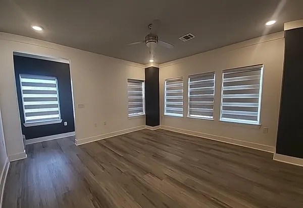 a view of a room with wooden floor and a kitchen space