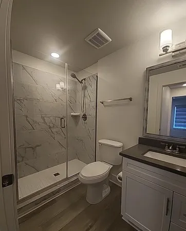a bathroom with a shower a toilet and sink