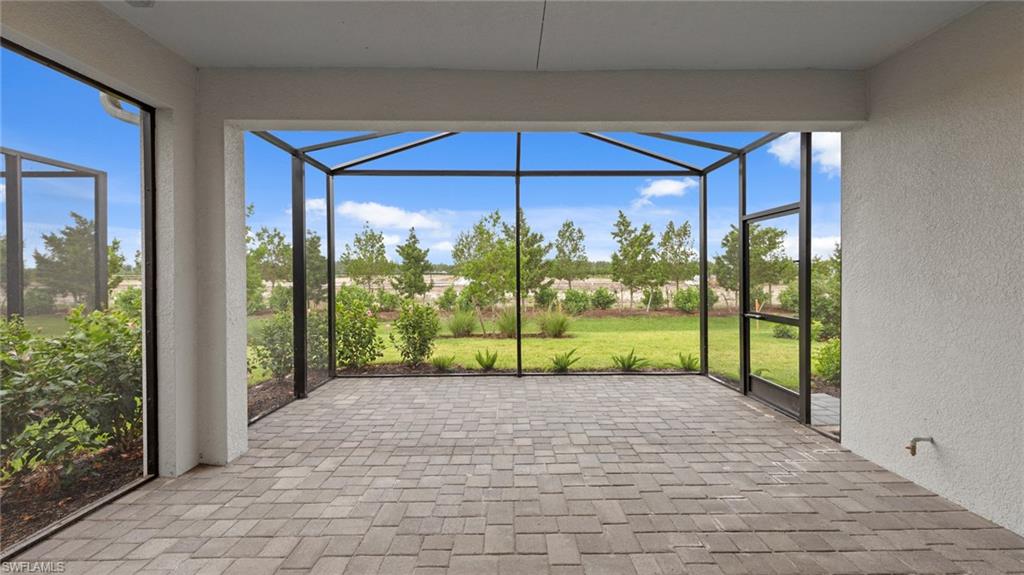 4636 Skysail Drive Naples, FL 34120 - Photo 27 of 46 a view of a porch with a floor to ceiling window next to a yard