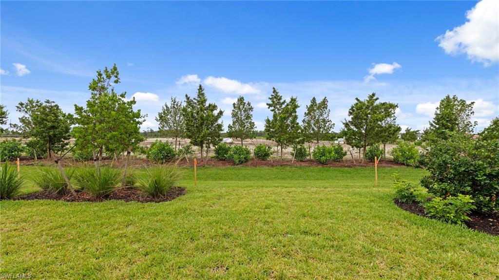 4636 Skysail Drive Naples, FL 34120 - Photo 33 of 46 a view of a grassy field with trees
