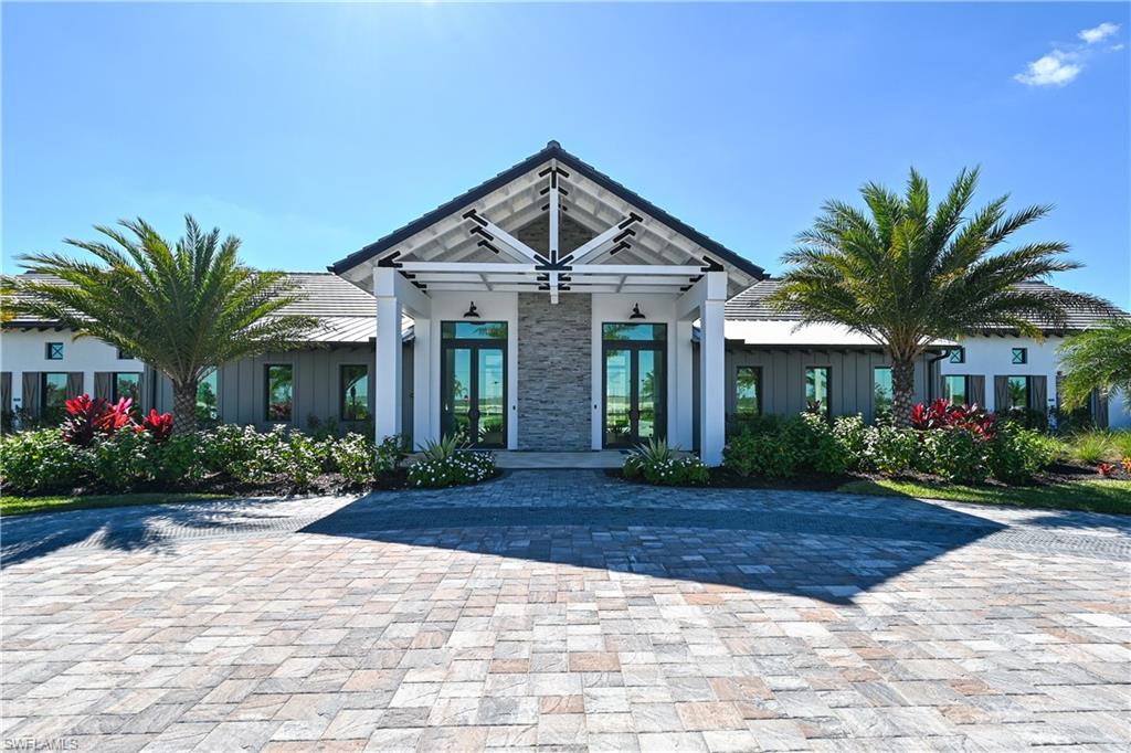 4636 Skysail Drive Naples, FL 34120 - Photo 40 of 46 a front view of a house with a yard and potted plants
