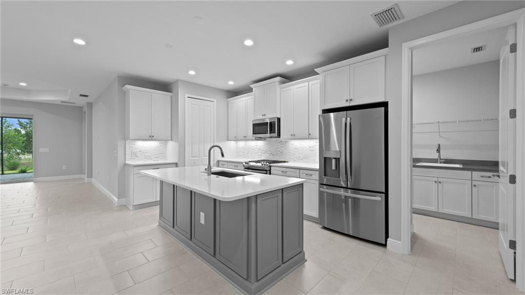 4636 Skysail Drive Naples, FL 34120 - Photo 6 of 46 a kitchen with refrigerator a sink and cabinets