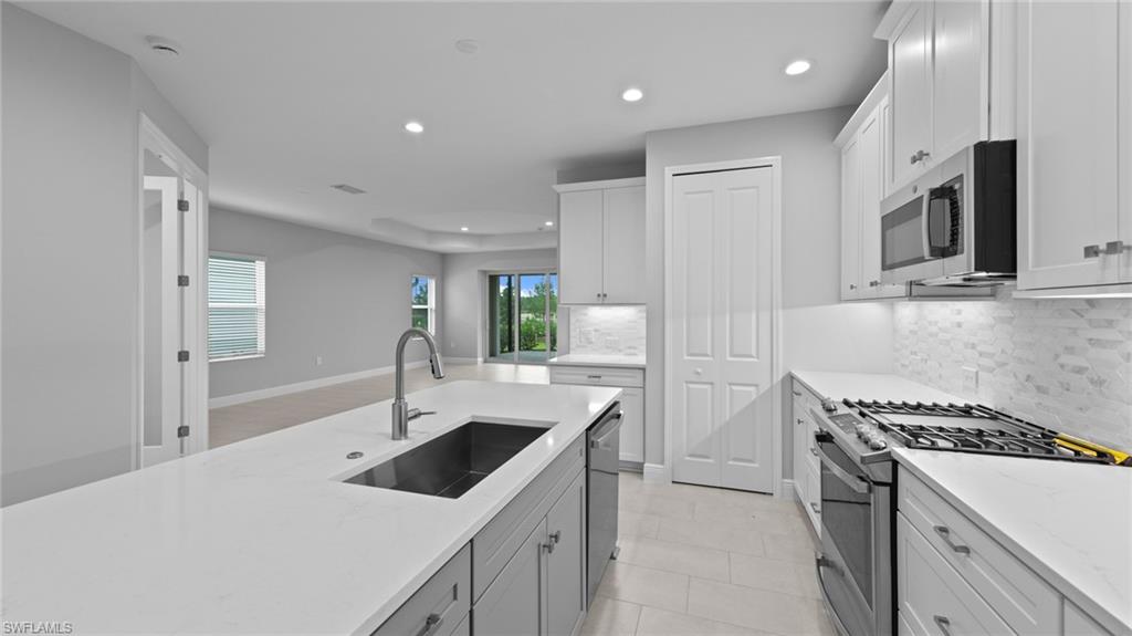 4636 Skysail Drive Naples, FL 34120 - Photo 8 of 46 a kitchen with a sink stove and refrigerator