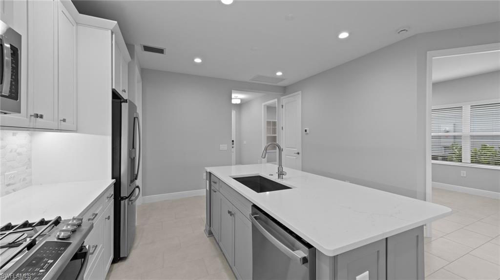 4636 Skysail Drive Naples, FL 34120 - Photo 9 of 46 a kitchen that has a sink a stove and a refrigerator