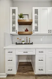 a living room with white cabinets and a wooden floor