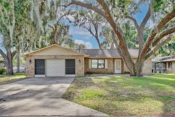a front view of a house with a yard and trees