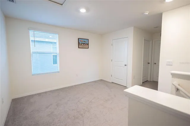 a view of an empty room with closet and a window