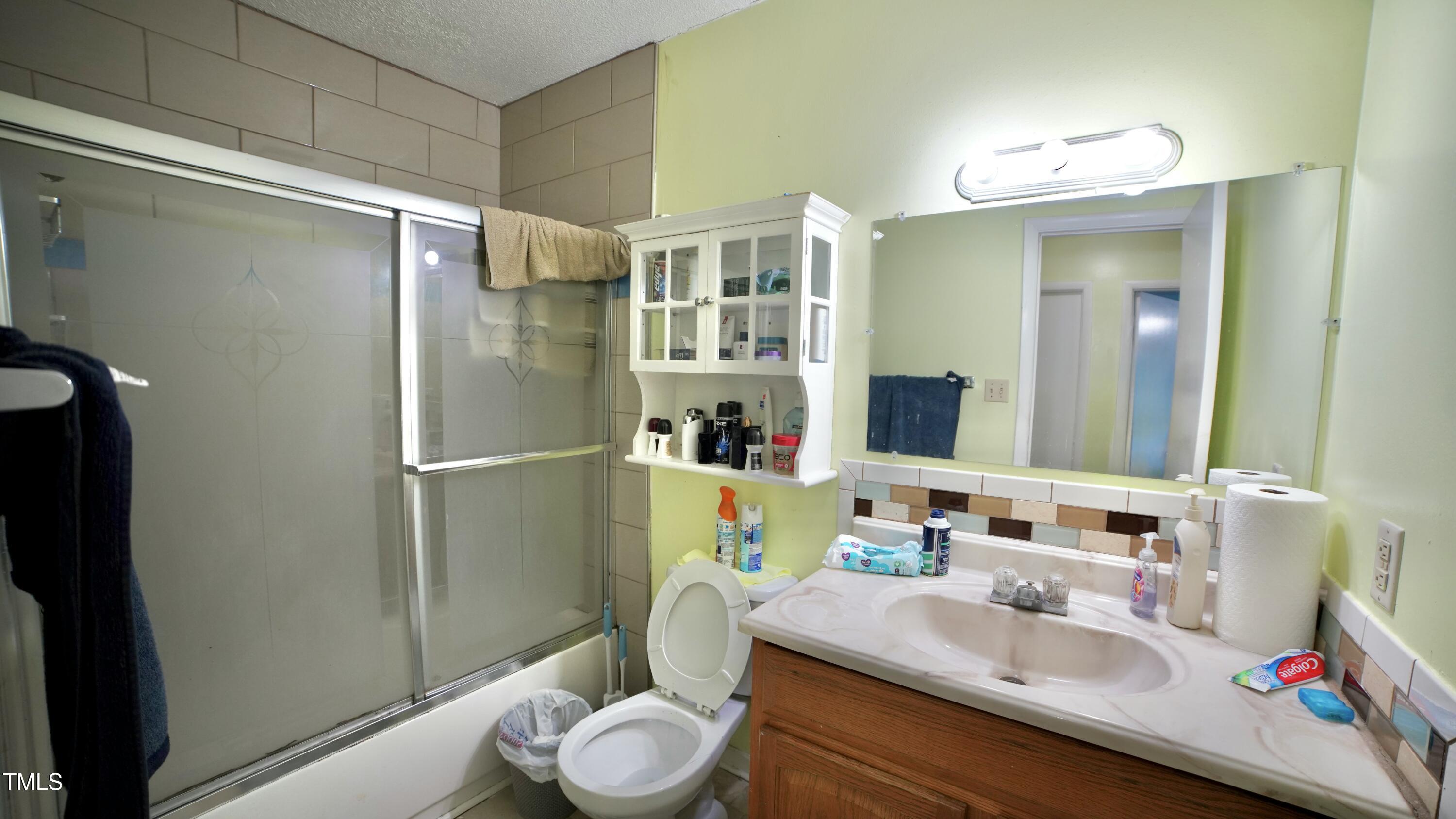 1011 Wyldewood Road Durham, NC 27704 - Photo 15 of 18 a bathroom with a sink toilet and shower