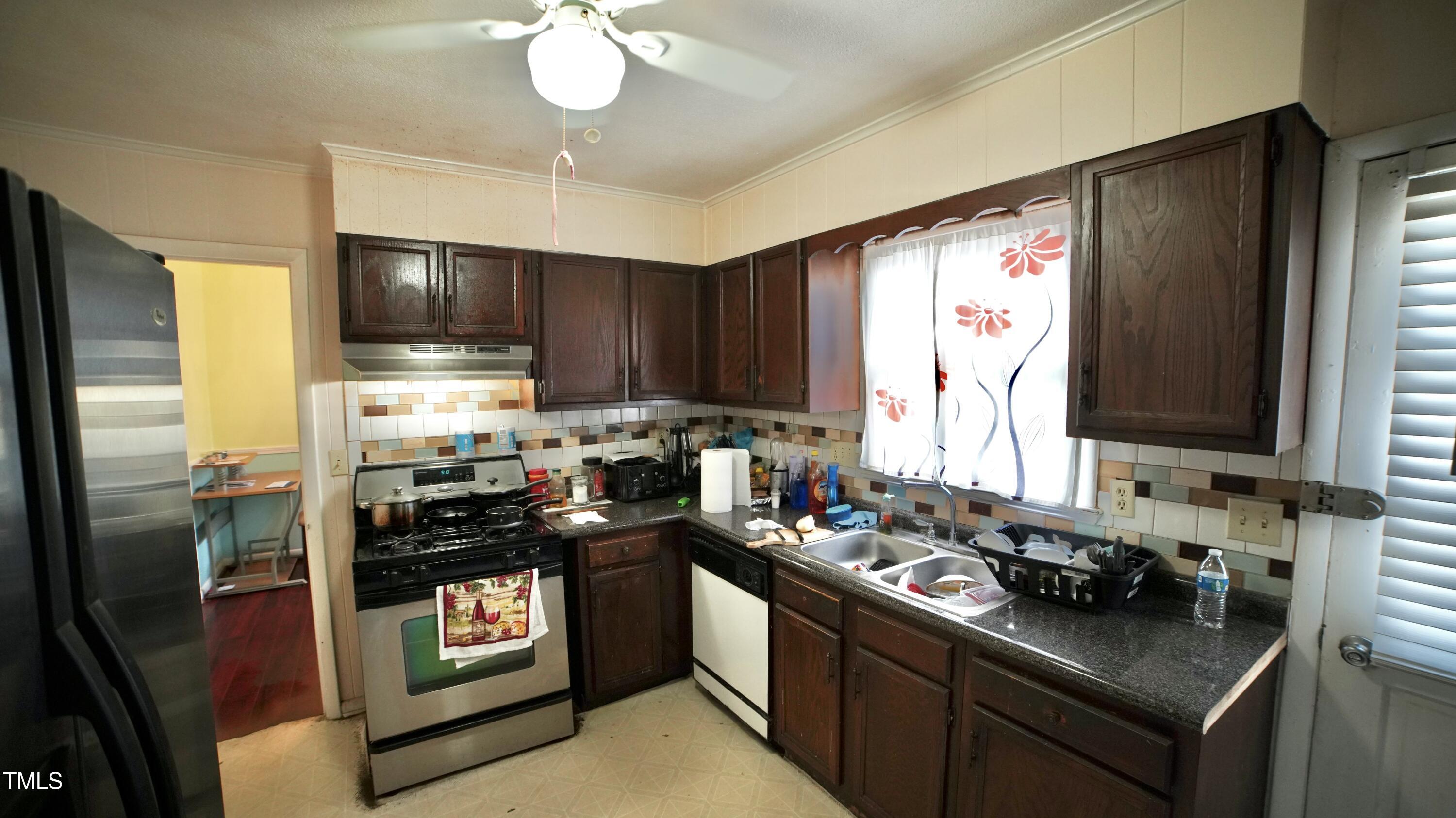 1011 Wyldewood Road Durham, NC 27704 - Photo 7 of 18 a kitchen with a stove a sink and a refrigerator