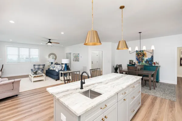 a kitchen with stainless steel appliances granite countertop a refrigerator a stove top oven a sink dishwasher and a refrigerator with wooden floor