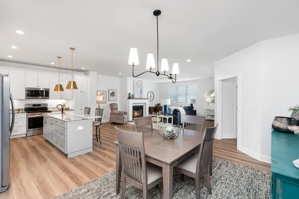 a kitchen with stainless steel appliances granite countertop a stove a sink dishwasher a refrigerator and a oven with wooden floor