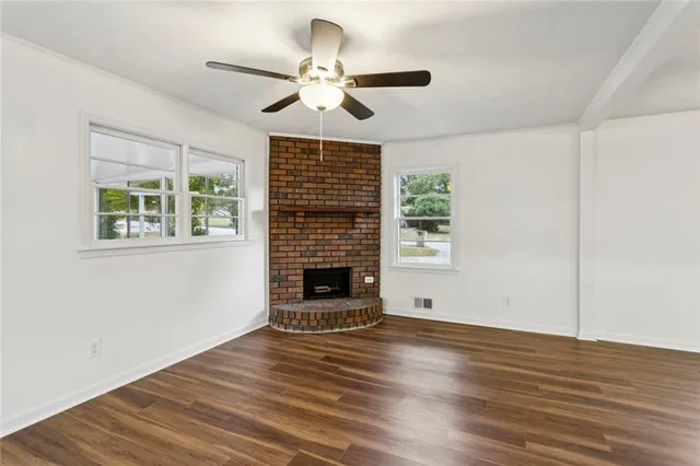 a view of wooden floor fire place refrigerator and window in a room