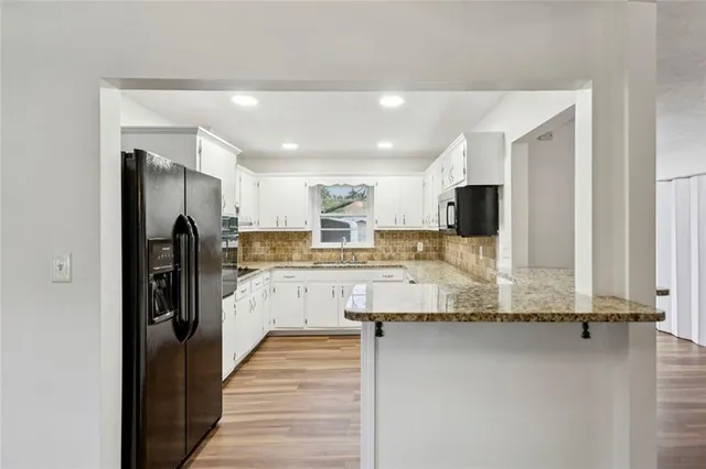 a kitchen with stainless steel appliances granite countertop a refrigerator and a sink