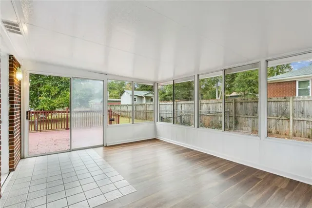 a view of empty room with wooden floor and floor to ceiling window