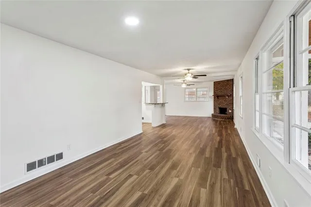 a view of empty room with wooden floor and windows