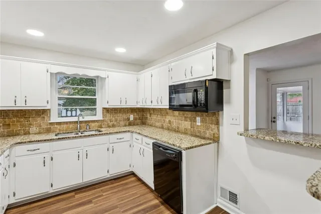 a kitchen with granite countertop white cabinets and white appliances
