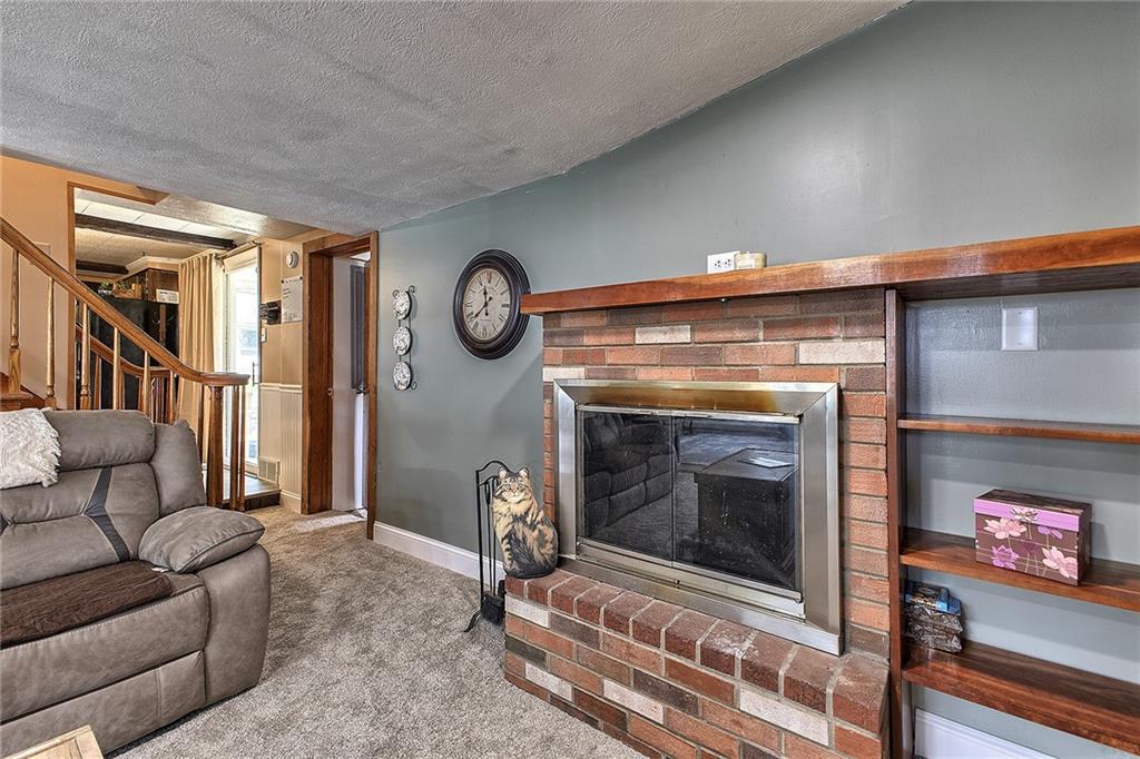 3456 Country Club Road Mount Pleasant, PA 15666 - Photo 30 of 39 a living room with furniture a clock and a fireplace