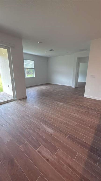 8780 Southwest Kanner Oaks Drive Stuart, FL 34997 - Photo 5 of 14 a view of an empty room with window and wooden floor