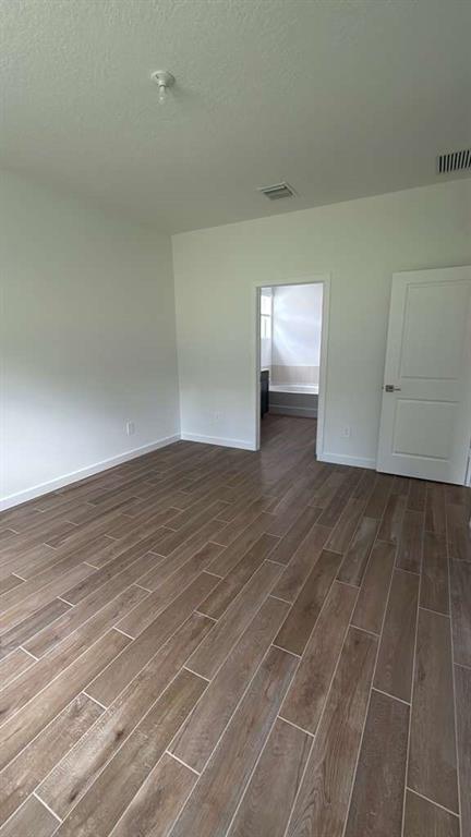 8780 Southwest Kanner Oaks Drive Stuart, FL 34997 - Photo 10 of 14 an empty room with wooden floor and windows