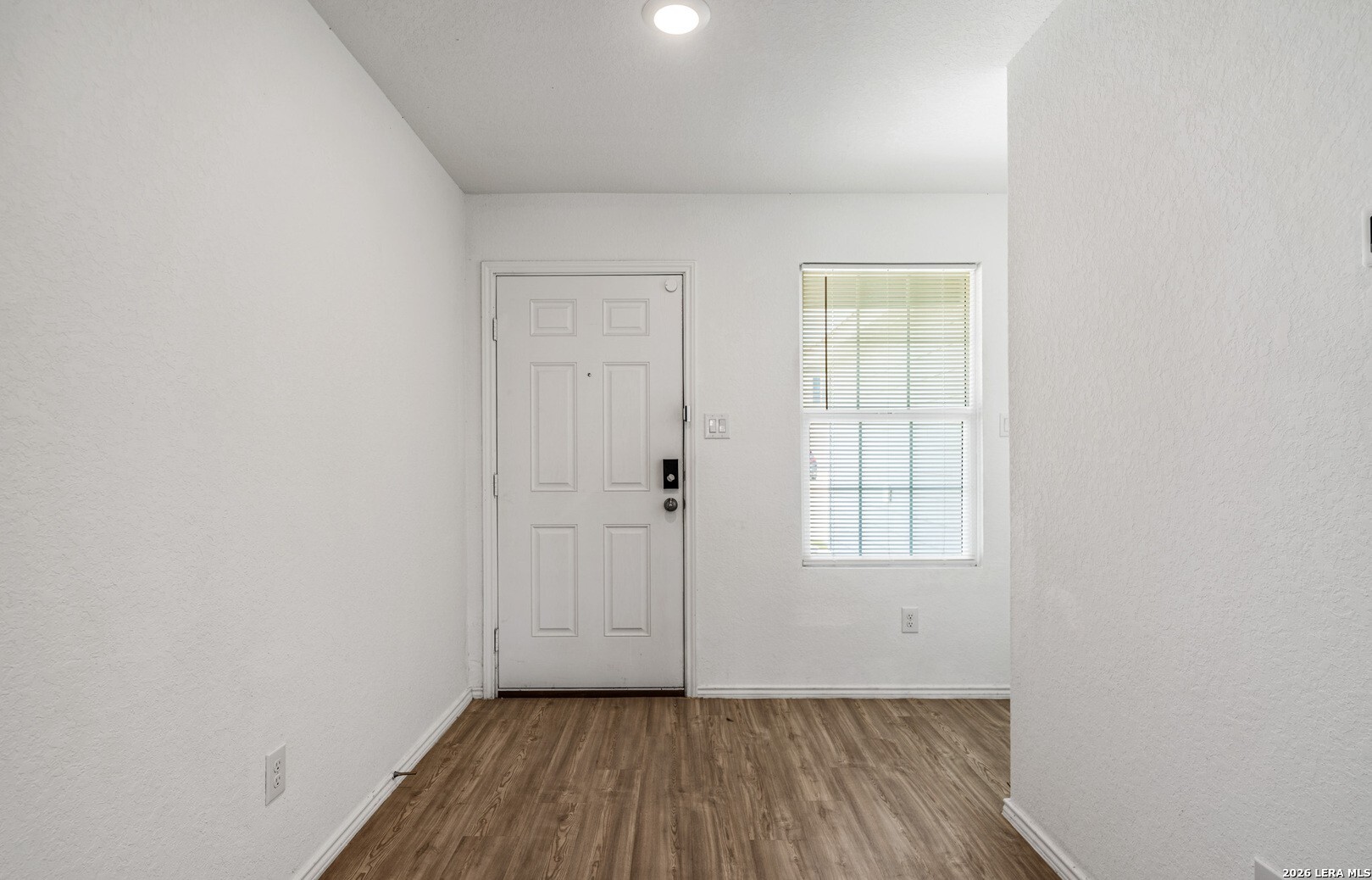 6566 Runaway Row Converse, TX 78109 - Photo 5 of 27 an empty room with wooden floor and windows