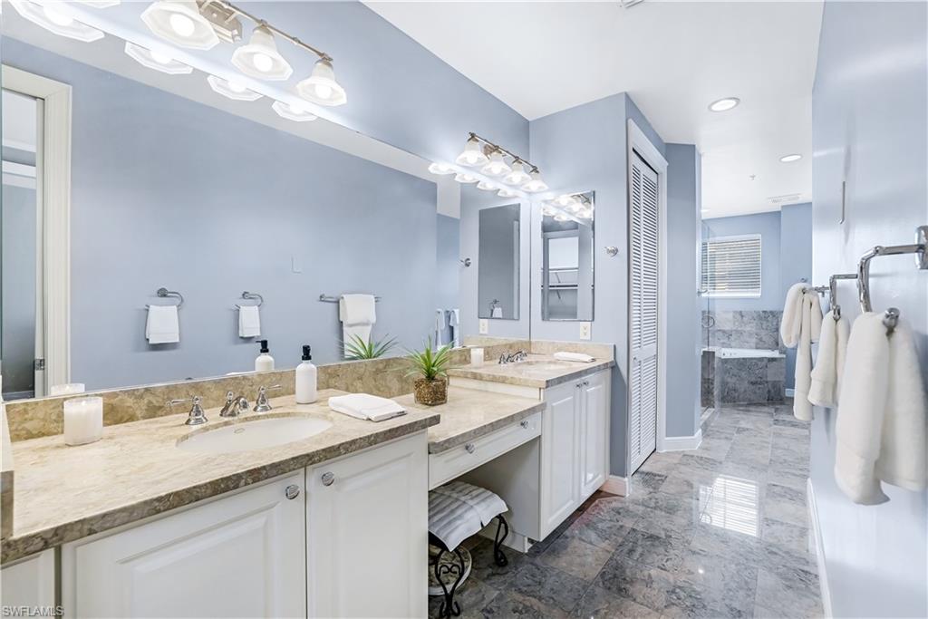 863 9th Avenue South, Unit 202 Naples, FL 34102 - Photo 17 of 35 a bathroom with a granite countertop sink a toilet a shower a mirror and vanity