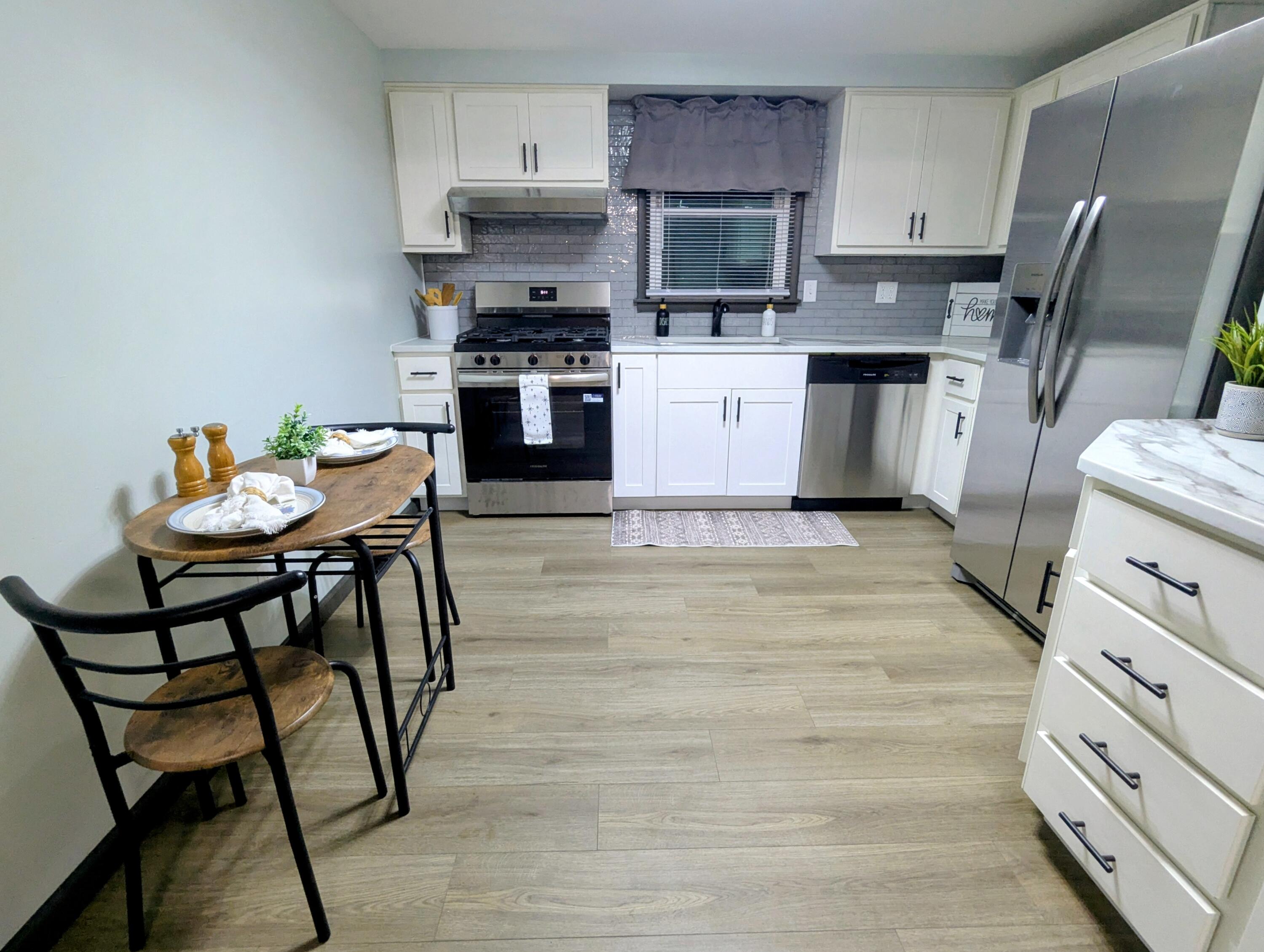 521 Ryan Road Hebron, IN 46341 - Photo 6 of 25 a kitchen with stainless steel appliances kitchen island granite countertop a table chairs microwave and sink